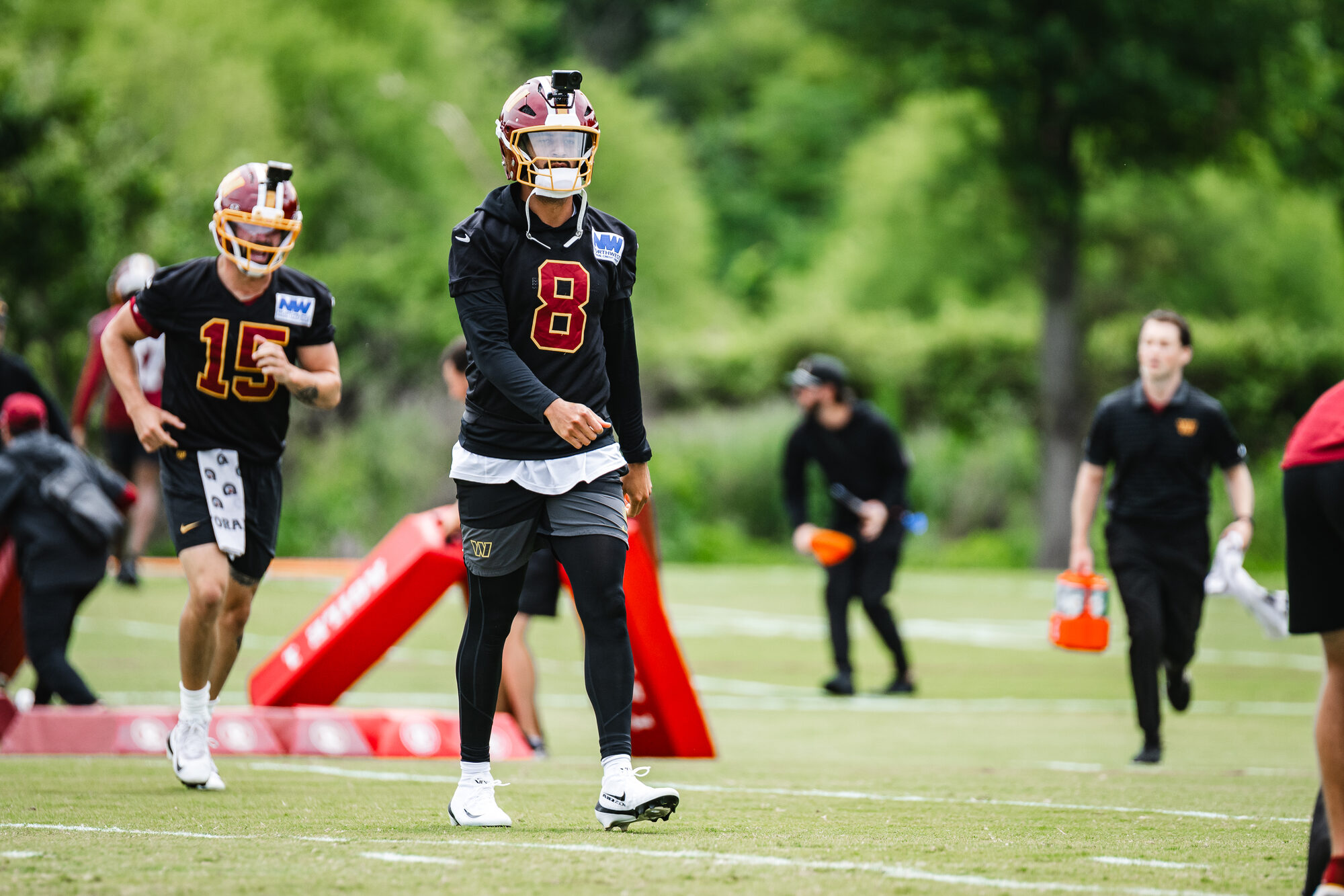 Washington Commanders quarterbacks Marcus Mariota and Sam Hartman run through a drill during OTA Session 3