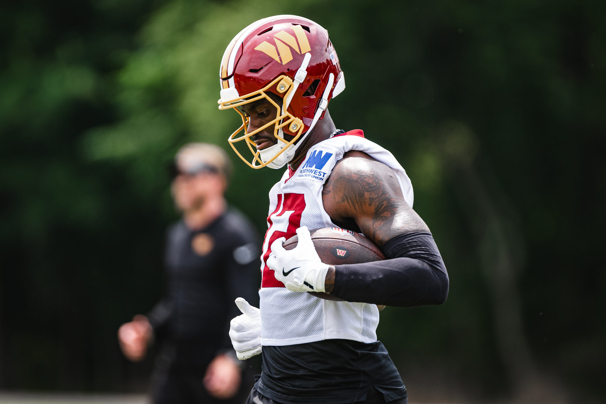 Washington Commanders player tucks the ball after a catch during OTA Session 3